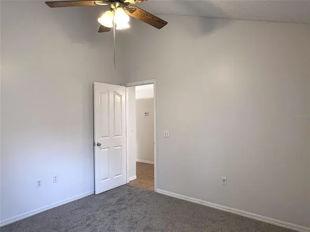 an empty room with a chandelier fan