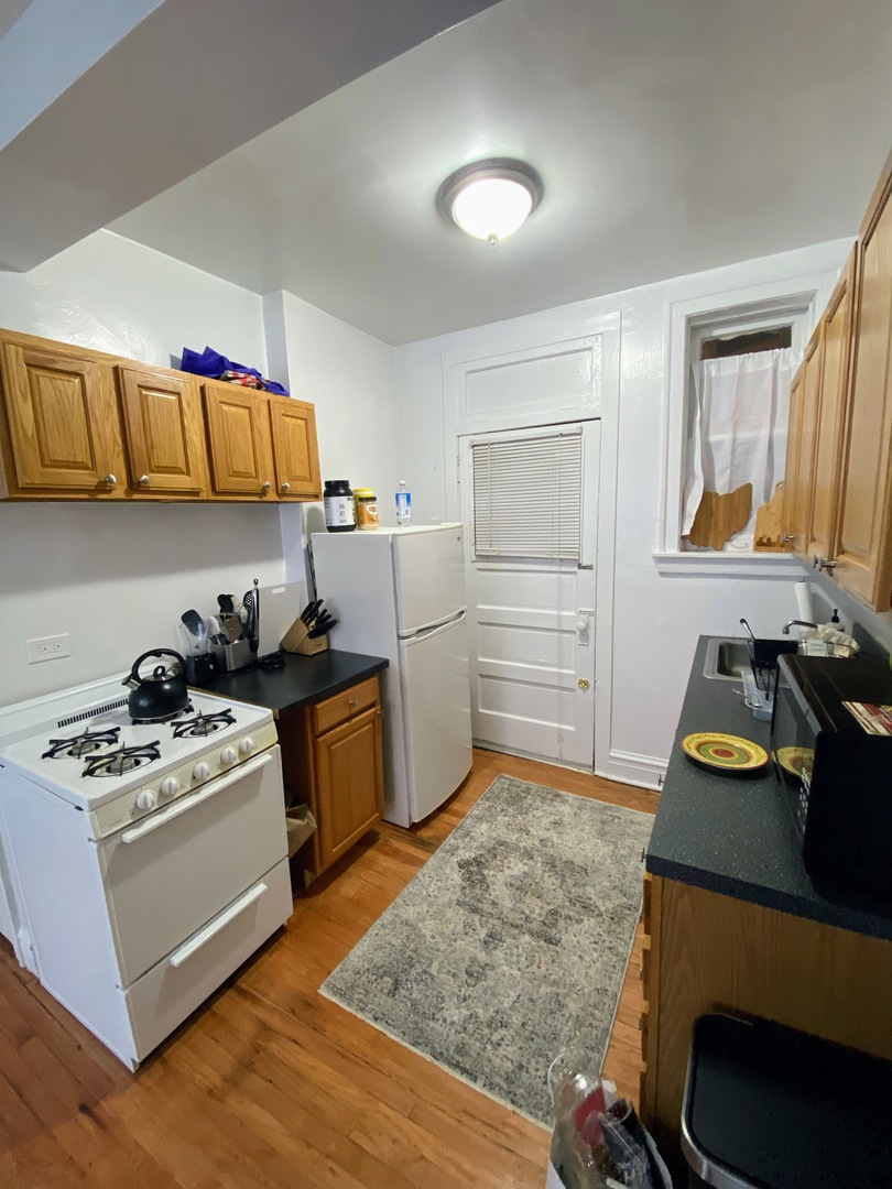 641 West Roscoe Street, Unit V2 Chicago, IL 60657 - Photo 3 of 9 a kitchen with a stove a refrigerator and cabinets