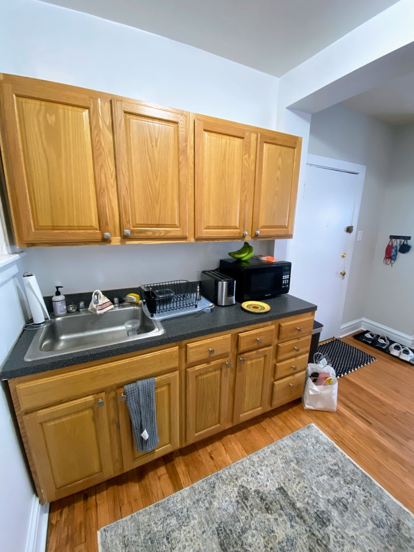 641 West Roscoe Street, Unit V2 Chicago, IL 60657 - Photo 4 of 9 a kitchen with stainless steel appliances granite countertop sink stove and cabinets