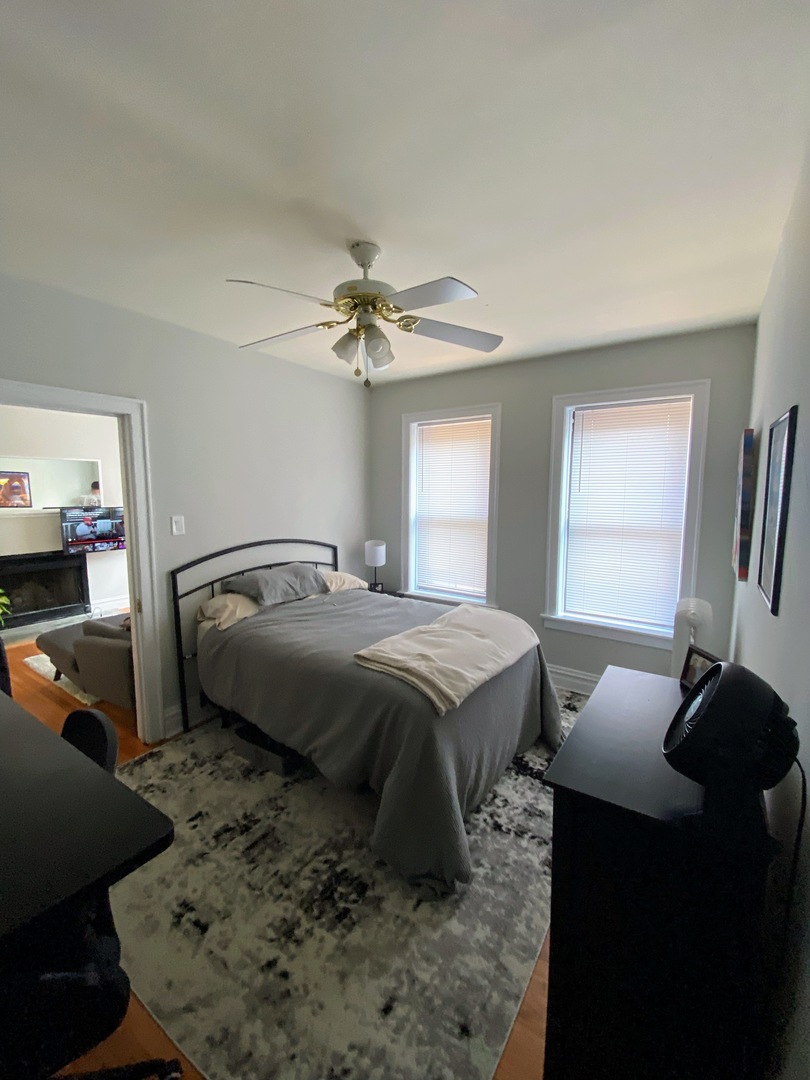 641 West Roscoe Street, Unit V2 Chicago, IL 60657 - Photo 8 of 9 a bedroom with a bed and a chandelier