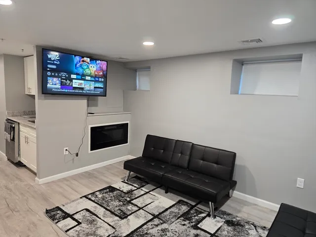 a living room with furniture a flat screen tv and a fireplace