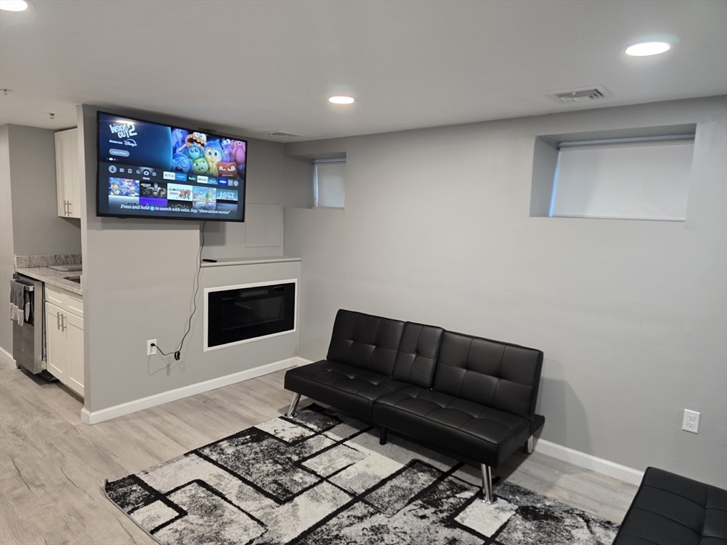 a living room with furniture a flat screen tv and a fireplace