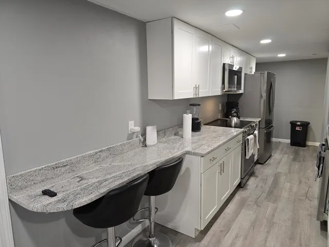 a kitchen with stainless steel appliances granite countertop a sink stove and cabinets