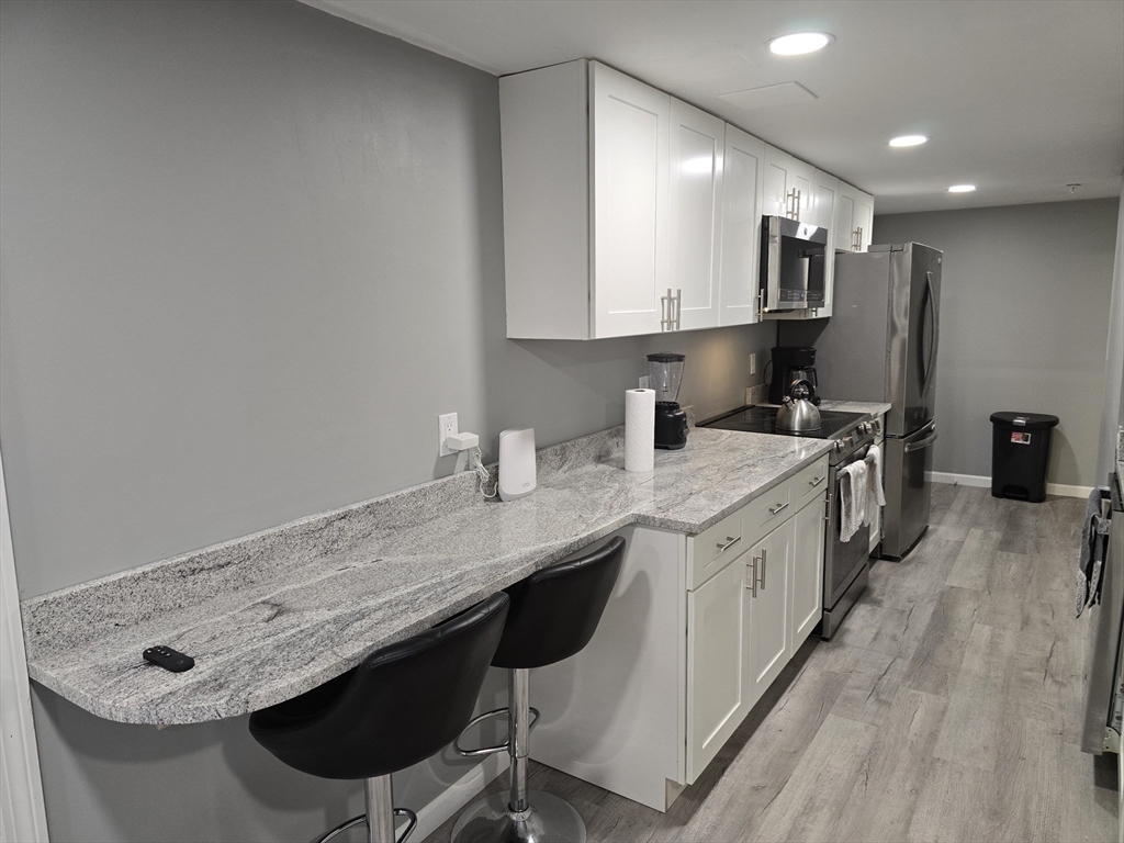 17 Rockingham Road, Unit B Boston, MA 02126 - Photo 6 of 10 a kitchen with stainless steel appliances granite countertop a sink stove and cabinets
