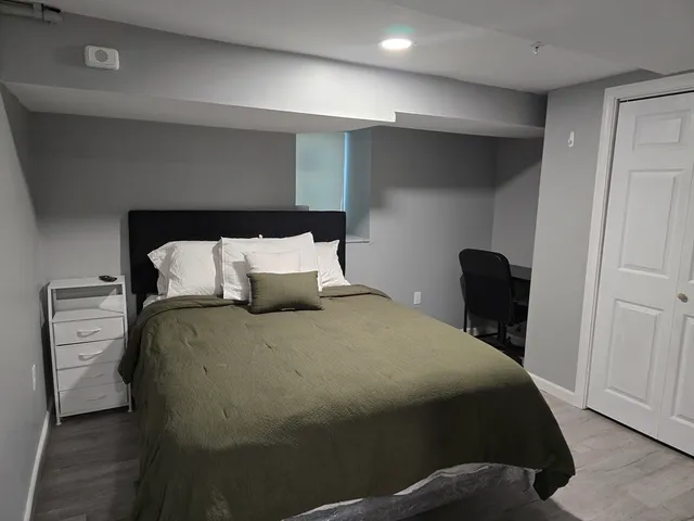 a bedroom with a bed and wooden floor