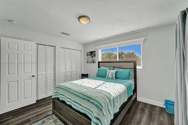 a kitchen with stainless steel appliances granite countertop a stove top oven a sink dishwasher a dining table and chairs with wooden floor