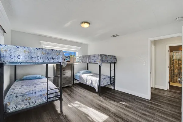a kitchen with stainless steel appliances a refrigerator and a hard wood floor