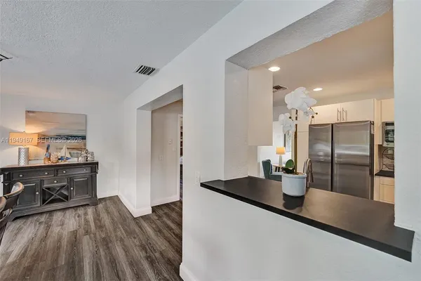 a view of a roof deck with table and chairs under an umbrella with wooden floor