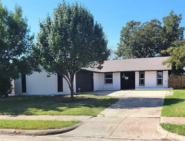 a front view of house with yard and trees