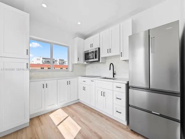 a kitchen with stainless steel appliances a refrigerator sink and cabinets