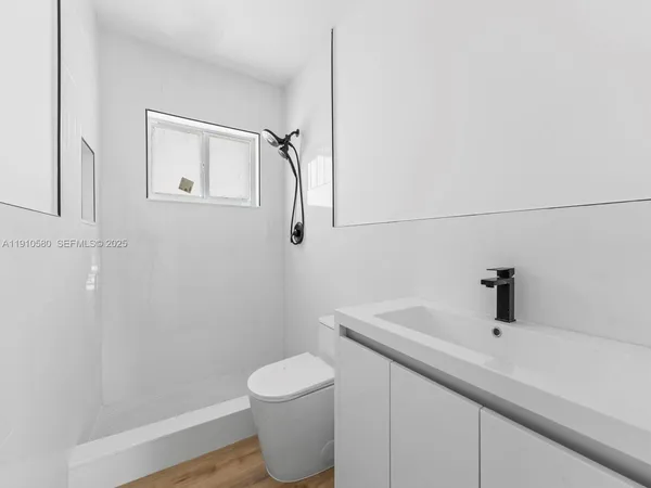 a bathroom with a sink a toilet and shower