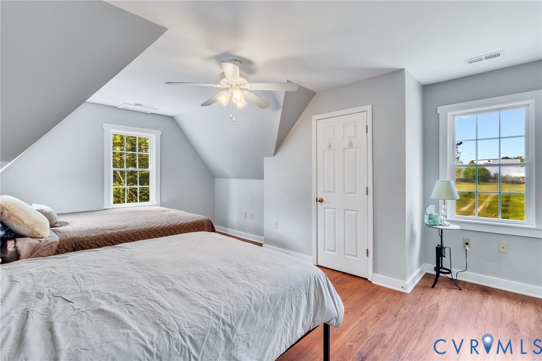 193 Deep Water Lane Reedville, VA 22539 - Photo 27 of 84 a bedroom with a bed windows and a chandelier