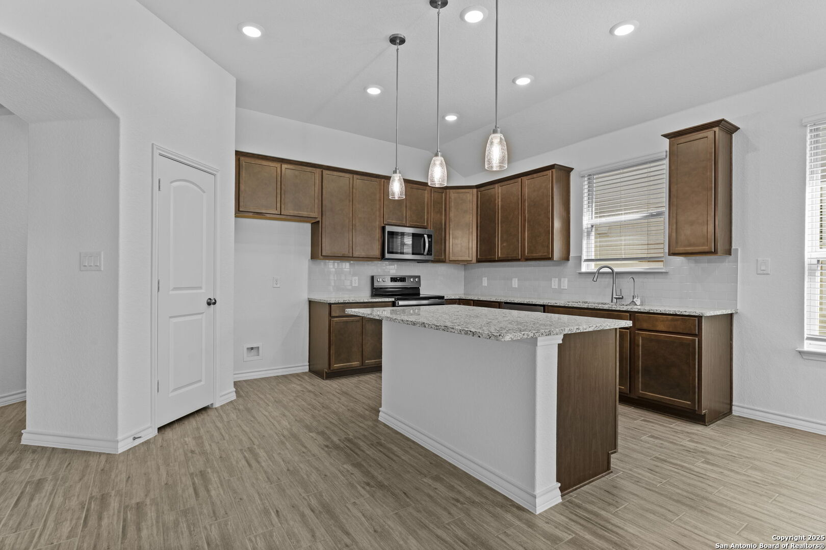 4040 Paddock Trail Seguin, TX 78155 - Photo 12 of 26 a large kitchen with stainless steel appliances granite countertop a stove a sink and a refrigerator