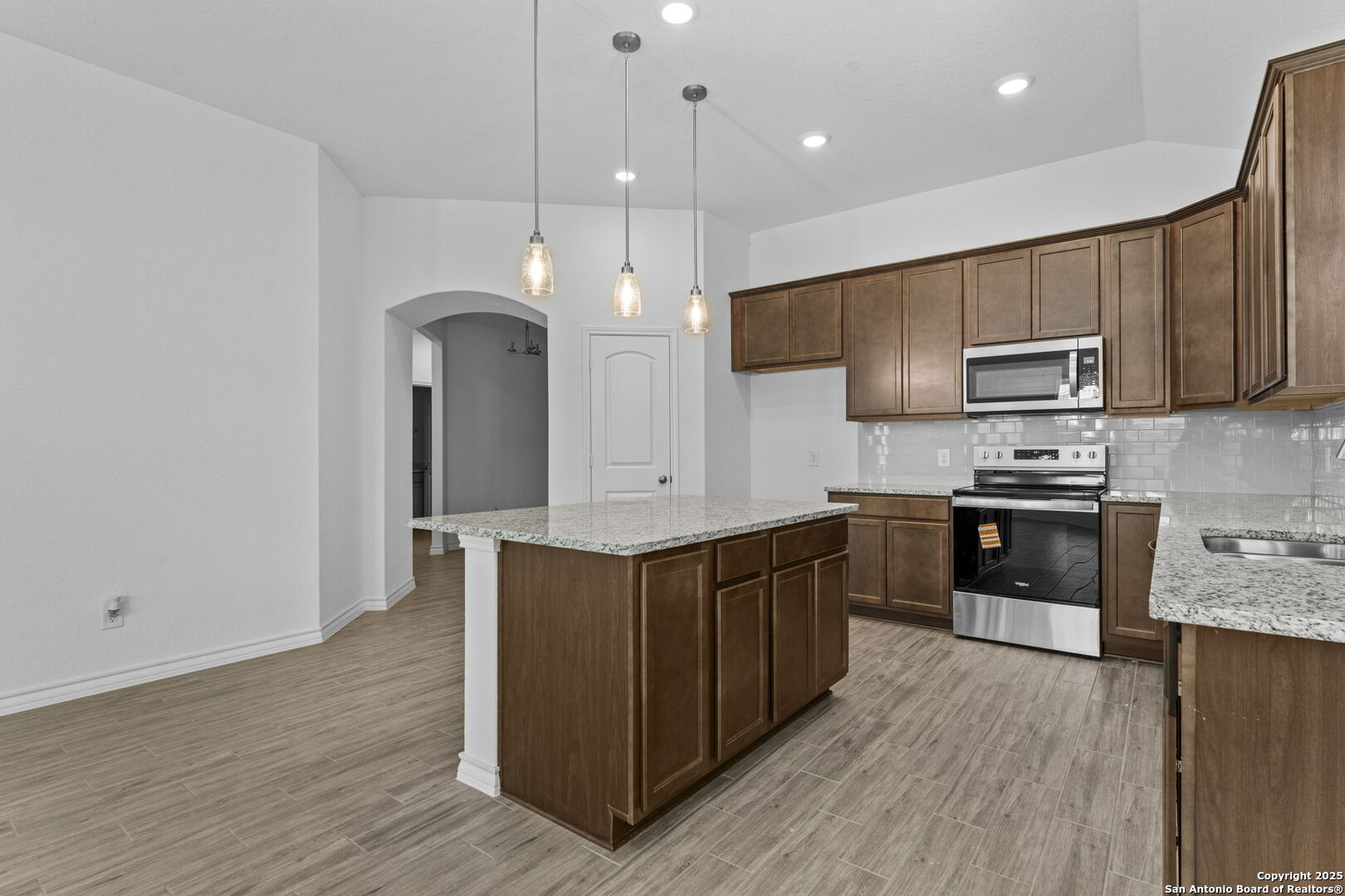 4040 Paddock Trail Seguin, TX 78155 - Photo 13 of 26 a large kitchen with stainless steel appliances granite countertop a stove a sink and a microwave