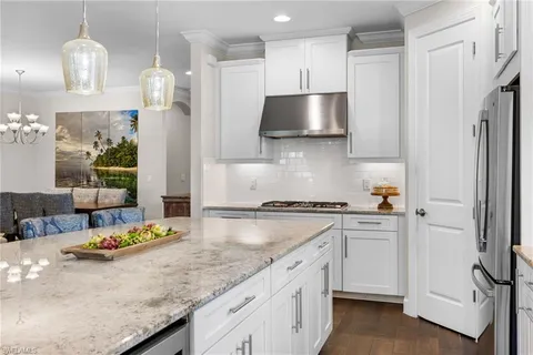 a large kitchen with kitchen island a large counter space a sink appliances and cabinets