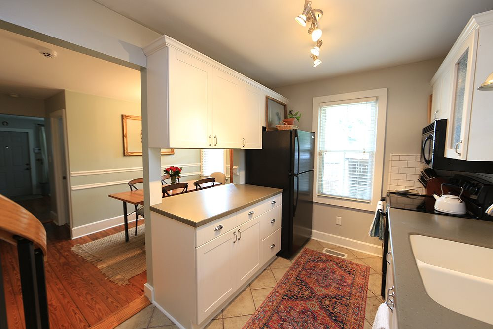 1530 Carson Street Raleigh, NC 27608 - Photo 6 of 21 Another view of the kitchen over looking the dining room. Kitchen features modern lighting and tile floor. Kitchen