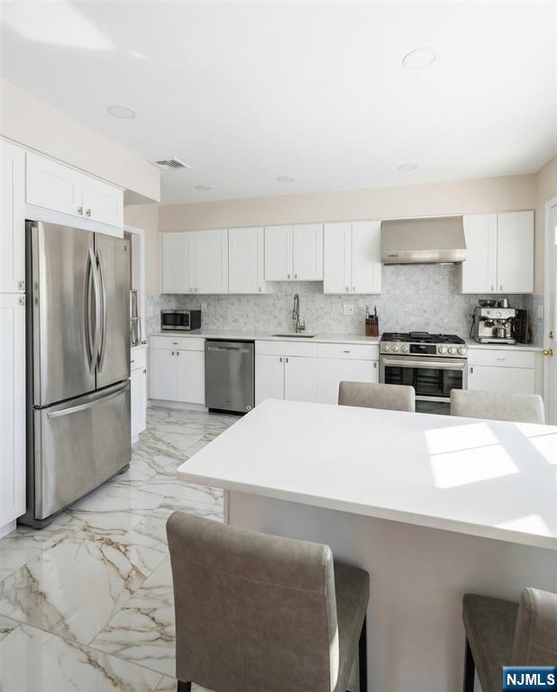 346 Alan Drive Paramus, NJ 07652 - Photo 18 of 21 a kitchen with stainless steel appliances a refrigerator stove microwave and sink