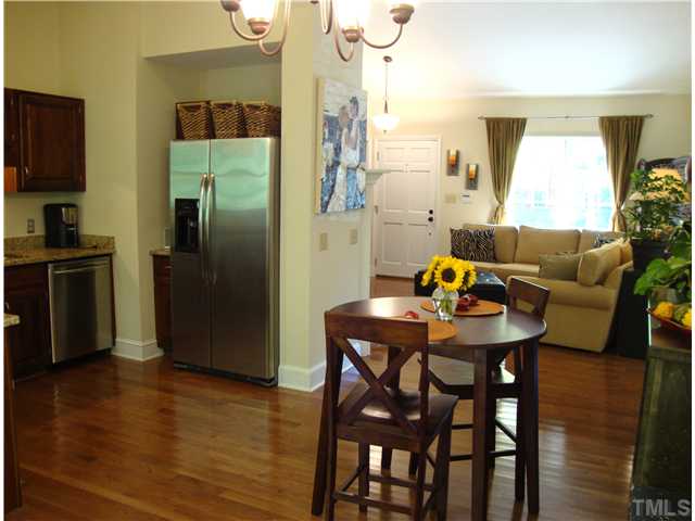 3209 Flintshire Road Raleigh, NC 27604 - Photo 8 of 25 a living room with stainless steel appliances furniture a desk and chair with wooden floor