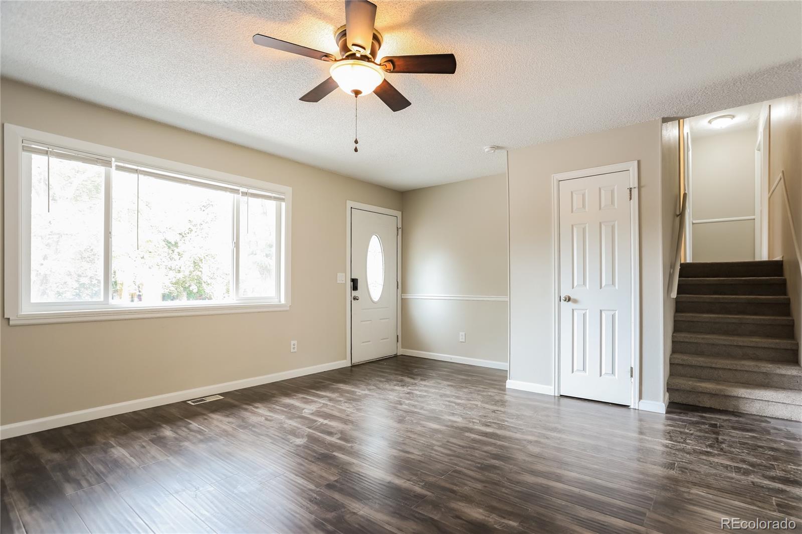 11580 East Ada Place Aurora, CO 80012 - Photo 2 of 18 a view of an empty room with wooden floor and a window