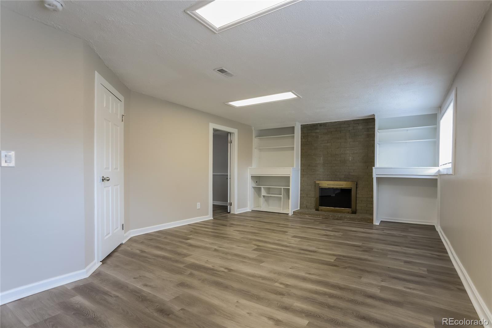 11580 East Ada Place Aurora, CO 80012 - Photo 6 of 18 a view of empty room with wooden floor fireplace
