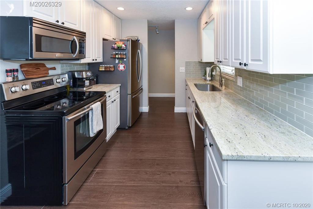 945 Sunset Road West Palm Beach, FL 33401 - Photo 11 of 31 a kitchen with stainless steel appliances granite countertop a stove a sink and a microwave