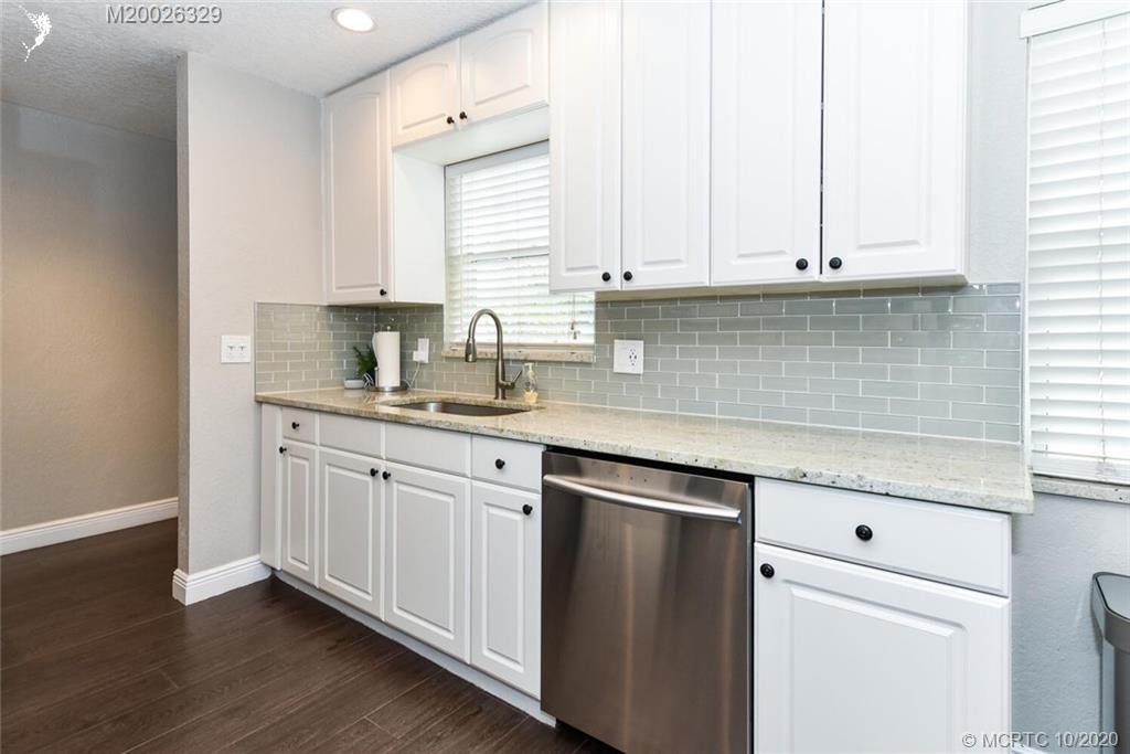 945 Sunset Road West Palm Beach, FL 33401 - Photo 12 of 31 a kitchen with granite countertop white cabinets and white appliances