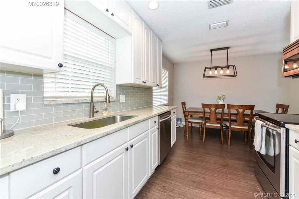 945 Sunset Road West Palm Beach, FL 33401 - Photo 13 of 31 a kitchen with white cabinets sink and dining table