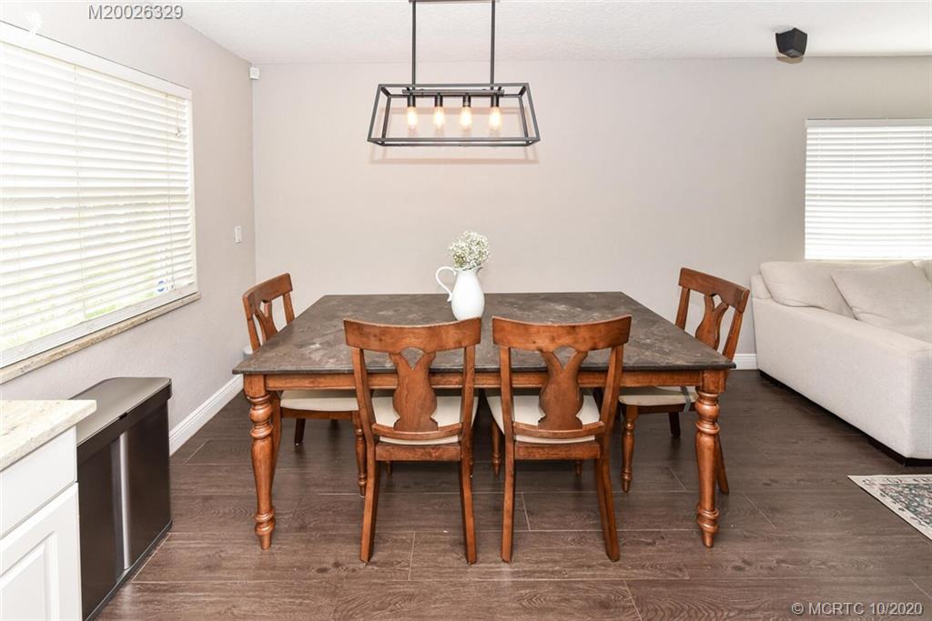 945 Sunset Road West Palm Beach, FL 33401 - Photo 15 of 31 a dining room with furniture a chandelier and wooden floor