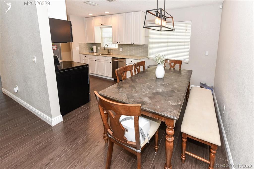 945 Sunset Road West Palm Beach, FL 33401 - Photo 17 of 31 a view of a dining room with furniture and wooden floor