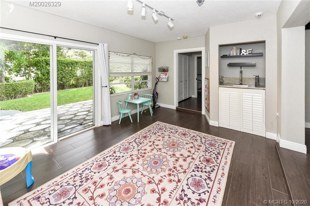 945 Sunset Road West Palm Beach, FL 33401 - Photo 21 of 31 a living room with a rug floor to ceiling window and wooden floor