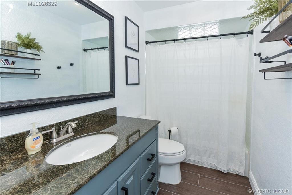945 Sunset Road West Palm Beach, FL 33401 - Photo 27 of 31 a bathroom with a granite countertop sink toilet and shower