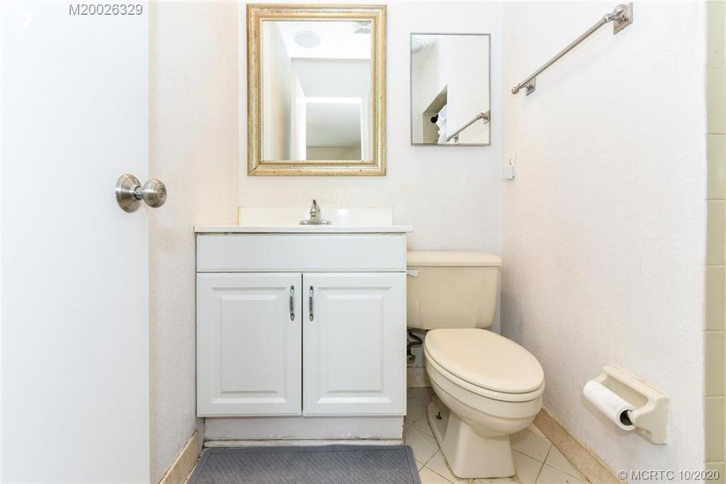 945 Sunset Road West Palm Beach, FL 33401 - Photo 29 of 31 a bathroom with a toilet a sink and mirror