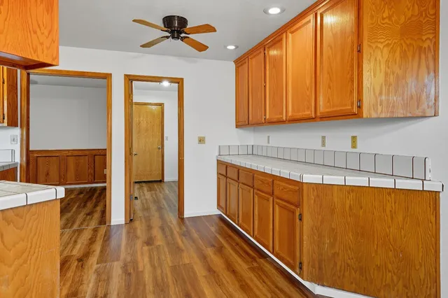 a view of a kitchen with wooden floor and cabinets