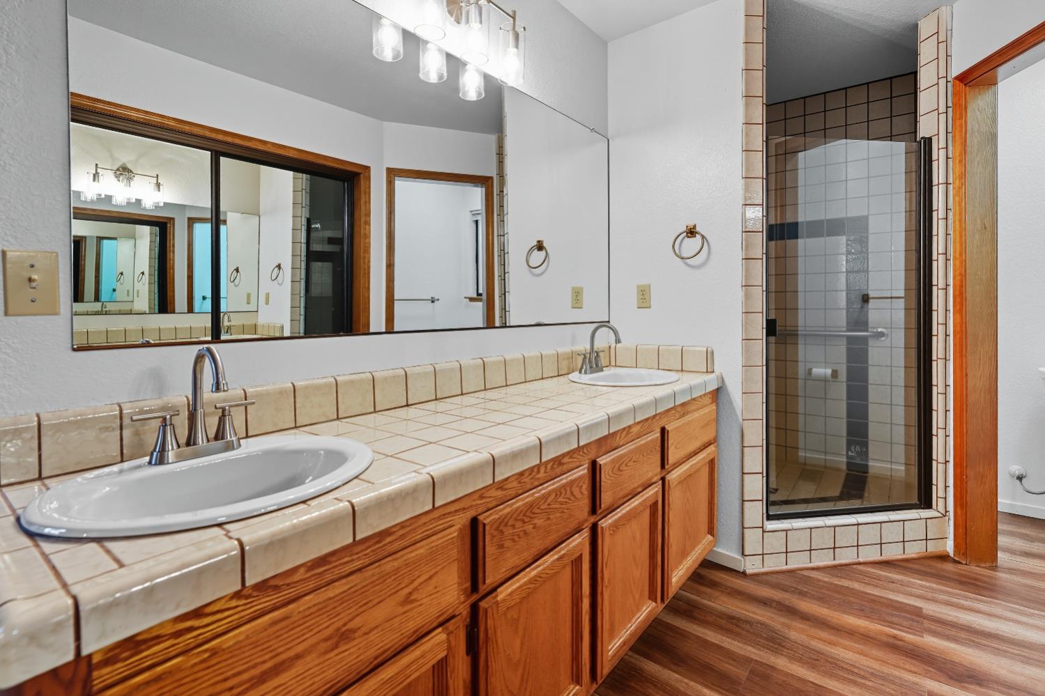 11585 Linnet Court Penn Valley, CA 95946 - Photo 16 of 49 a bathroom with a granite countertop sink a mirror and a shower