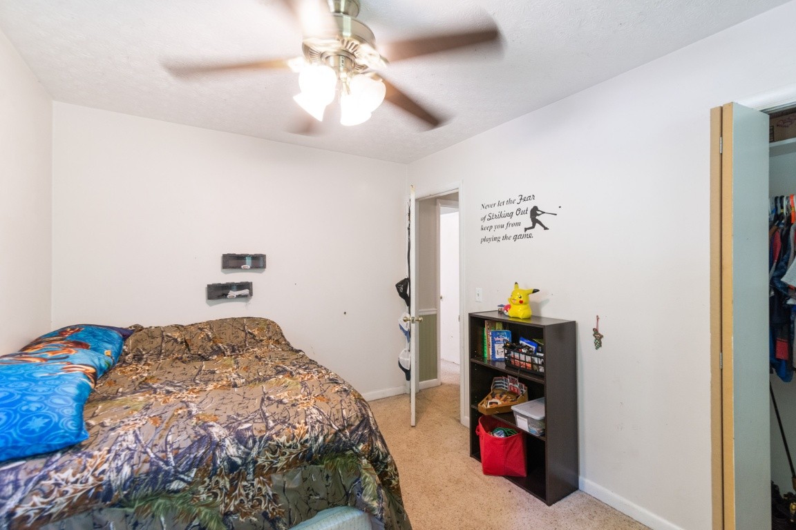739 Thompson Road Pegram, TN 37143 - Photo 14 of 35 a bedroom with a bed and a chandelier