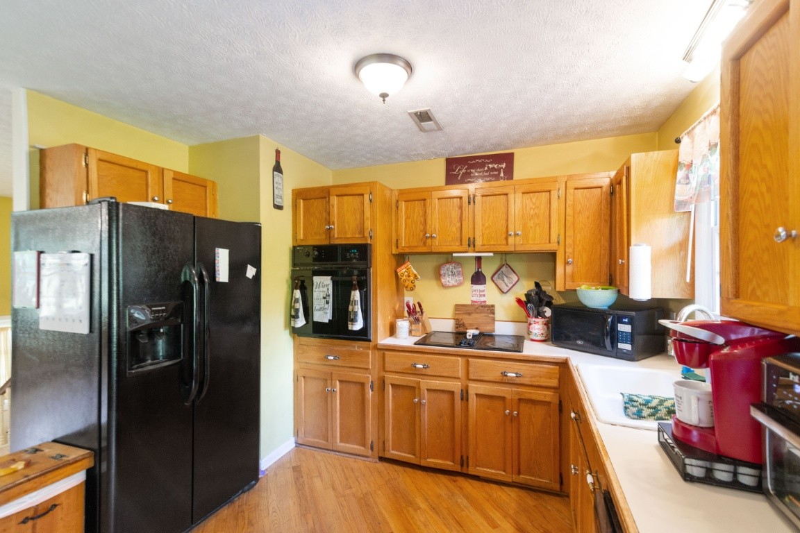 739 Thompson Road Pegram, TN 37143 - Photo 8 of 35 a kitchen with stainless steel appliances a refrigerator sink and cabinets