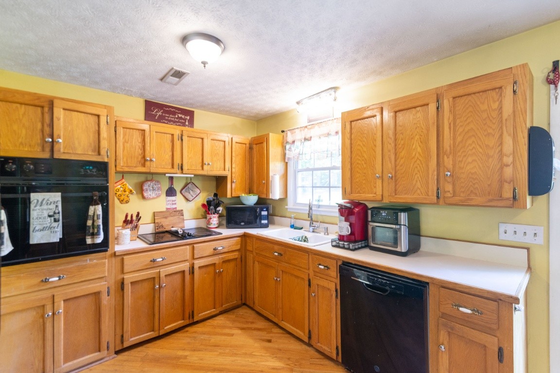 739 Thompson Road Pegram, TN 37143 - Photo 9 of 35 a kitchen with stainless steel appliances granite countertop a sink a stove cabinets counter space and a window