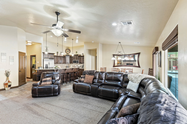 210 Talon Court Ivins, UT 84738 - Photo 12 of 60 Living area with ceiling fan, light carpet, and a high textured ceiling