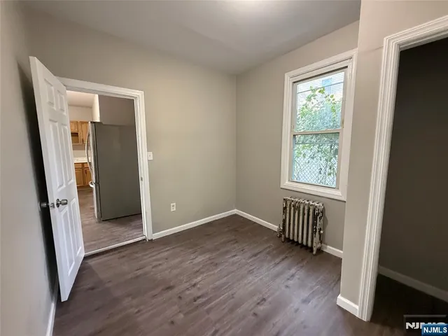 an empty room with wooden floor and a window