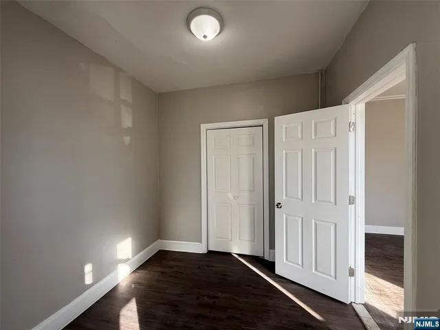 an empty room with wooden floor and closet