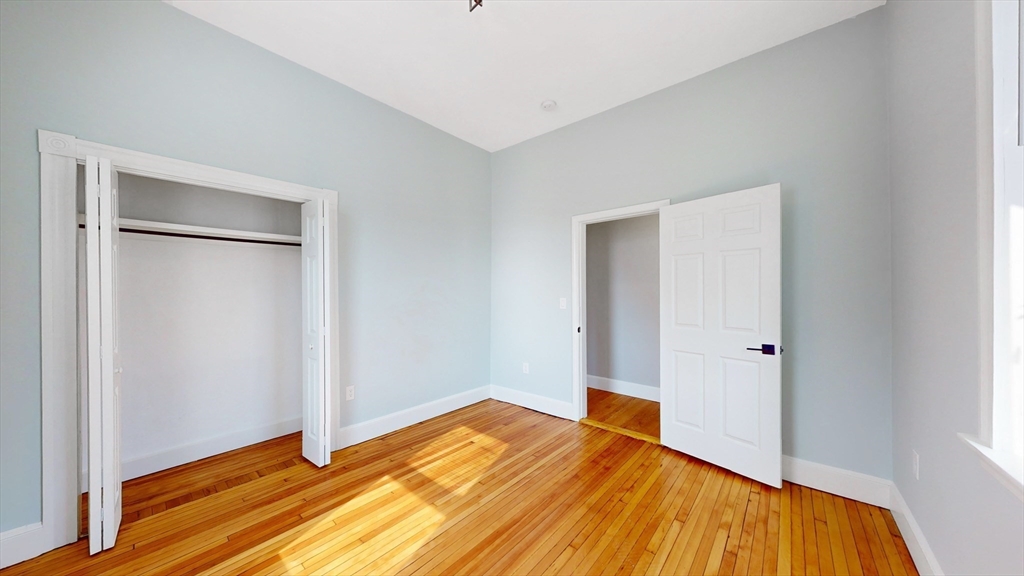 181 Highland Street, Unit 1 Boston, MA 02119 - Photo 10 of 11 a view of room with wooden floor