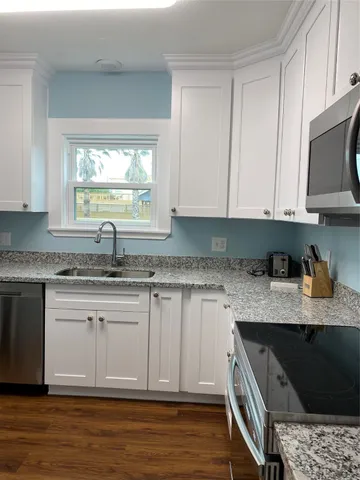 a kitchen with stainless steel appliances granite countertop a sink a stove and a microwave