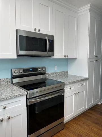a kitchen with stainless steel appliances granite countertop a stove microwave and oven