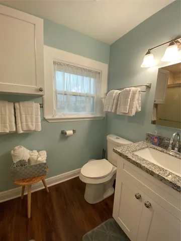 a bathroom with a granite countertop toilet sink and mirror