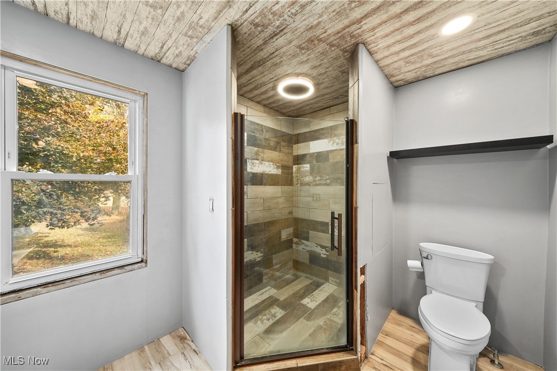 14080 Nash Road Burton, OH 44021 - Photo 7 of 49 Bathroom featuring toilet, an enclosed shower, and hardwood / wood-style flooring