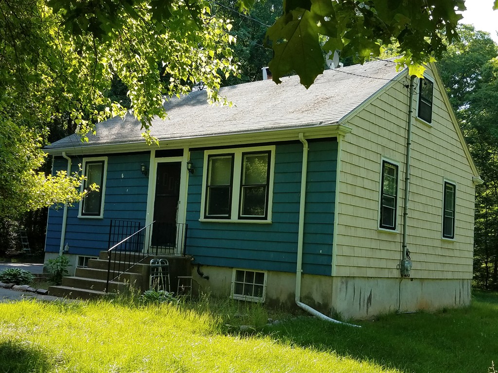 a view of a house with a yard and sitting area