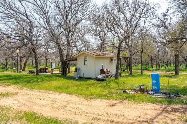 a view of a house with a big yard and large trees