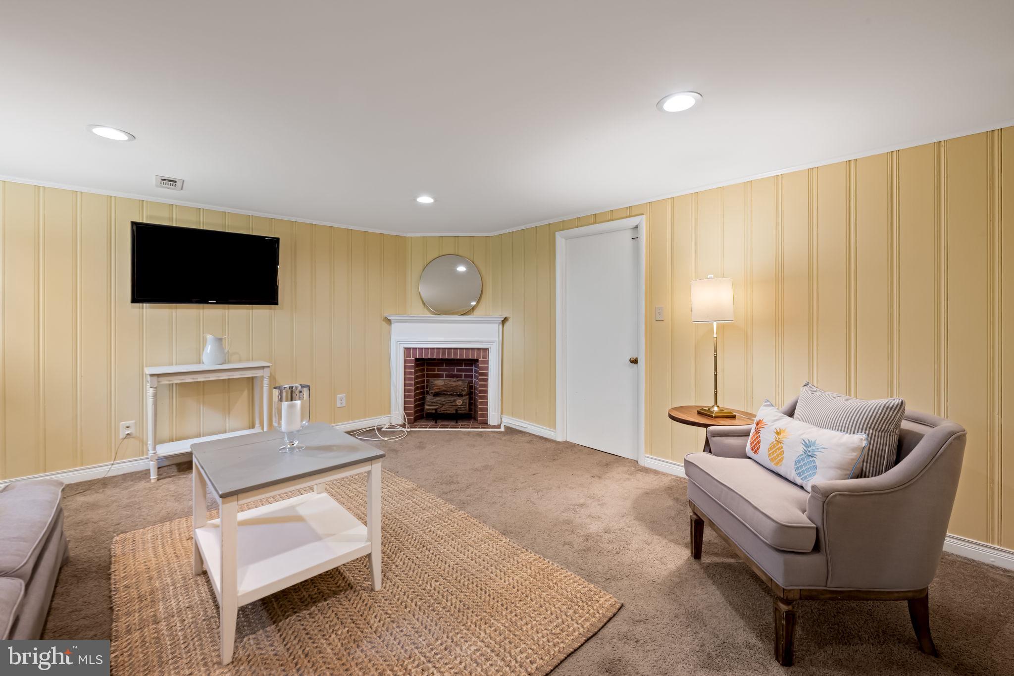 210 Stanmore Road Baltimore, MD 21212 - Photo 27 of 39 a living room with furniture a fireplace and a flat screen tv