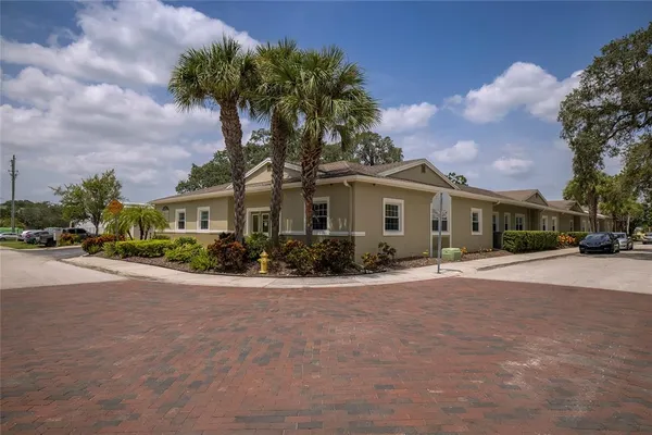 a front view of a house with a garden and car parked