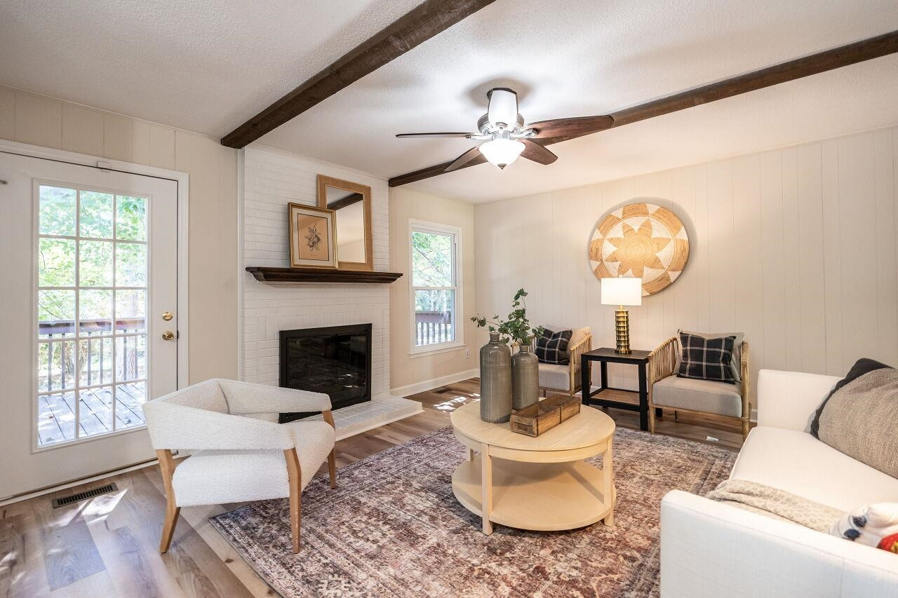 3300 Blue Ridge Road Raleigh, NC 27612 - Photo 12 of 25 a living room with furniture a chandelier and a fireplace